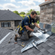 Professional roofing contractor installing roof flashing to prevent water leaks and protect a residential roof from moisture damage.