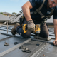 Professional roofing contractor replacing loose roof screws on a metal roof to prevent leaks and extend the roof's lifespan.
